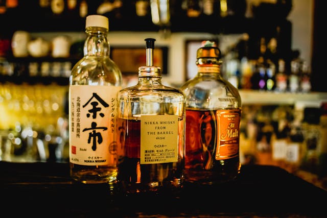 Three assorted bottles of Japanese whisky on a table.