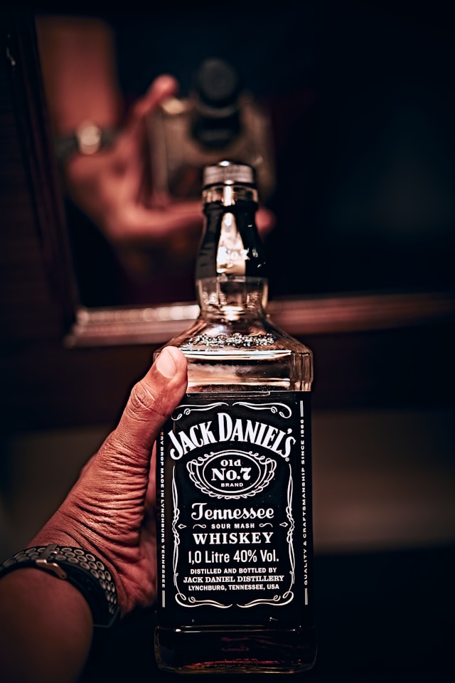 A person holding a bottle of Jack Daniel's Tenesse whiskey.