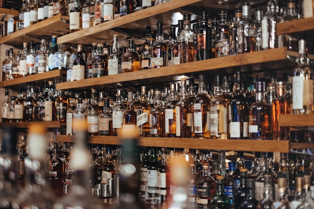 A well-stocked whisky bar shelf featuring rows of various whisky bottles.