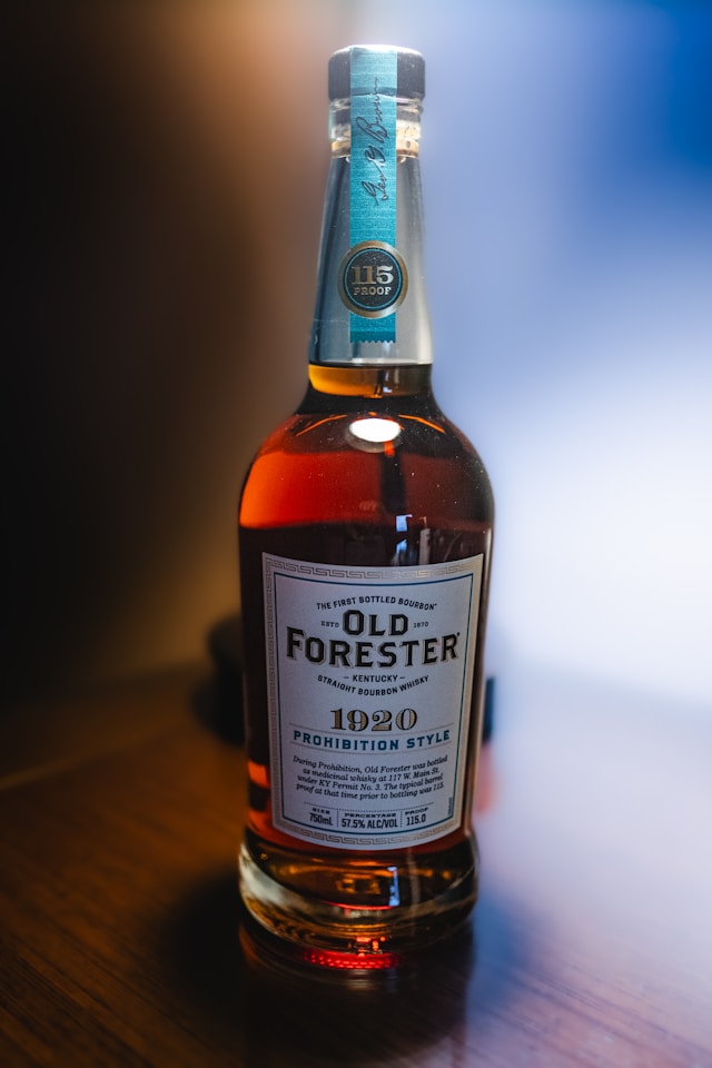 A bottle of Old Forester 1920-Prohibition Style on a wooden table.