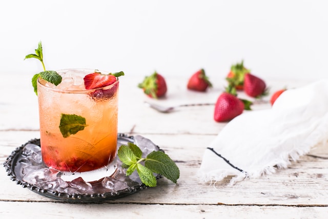 A Strawberry Mint Whiskey Smash served in a chilled glass, featuring muddled strawberries and mint.