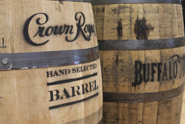 Close-up of two wooden bourbon barrels with metal bands, labeled with "Crown Royal Hand Selected Barrel" and "Buffalo Trace."