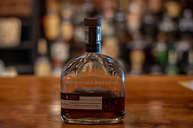 A close-up of a bottle of Woodford Reserve Double Oaked Kentucky Straight Bourbon Whiskey on a wooden table. 