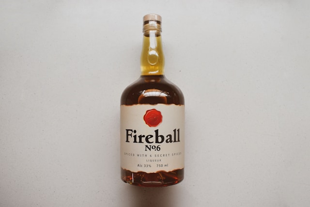 A Fireball No.6 whiskey bottle lying flat against a clean, light-colored surface.